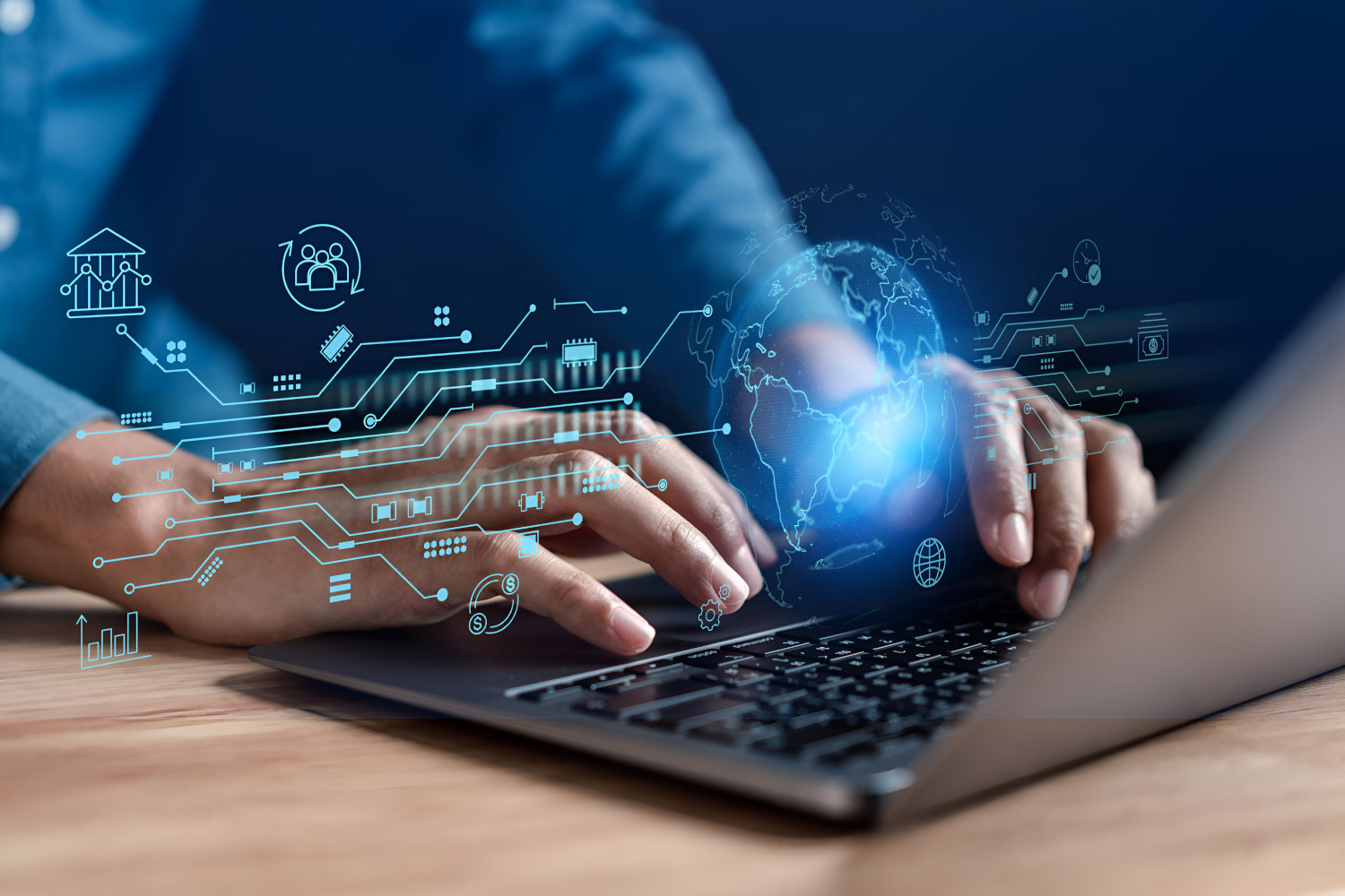 Hands typing on a laptop with a globe outline and various graphs projected above it